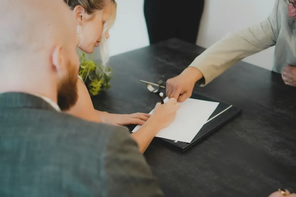 Couple signing estate planning documents at a desk