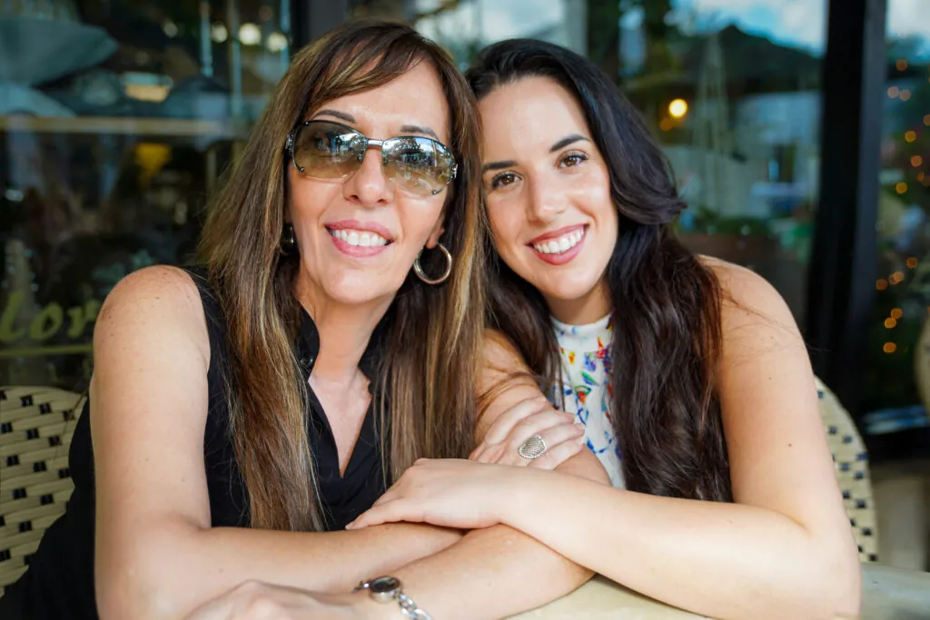 Mena and Rocki Maimone smiling together at a table, the family behind an immigration law firm in Fort Lauderdale
