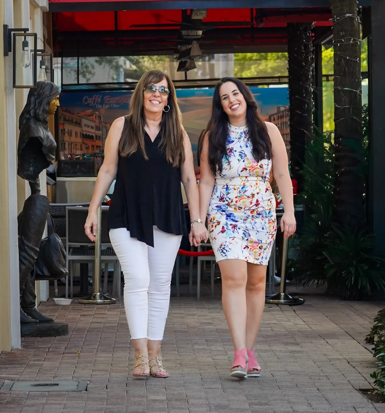 Mena and Rocki Maimone walking together outdoors, the mother-daughter team behind Maimone Legal